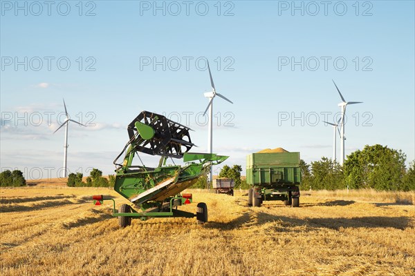Harvester in a field of cultivated barley in Germany, harvest in the summer, agriculture for food,