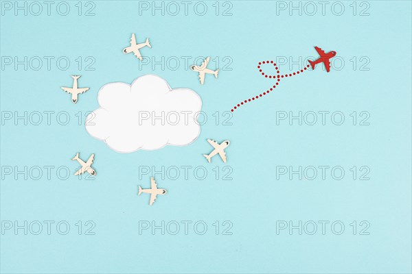 Group of airplanes flying in a circle around a cloud, red plane thinks different and takes the