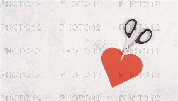 Red heart cut by the scissors, symbol for broken relationship, love and emotion concept, divorce