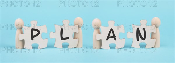 The word plan is standing on puzzle pieces, connect the parts together, corporate in teamwork,
