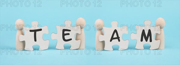The word team is standing on puzzle pieces, connect the parts together, corporate in teamwork,