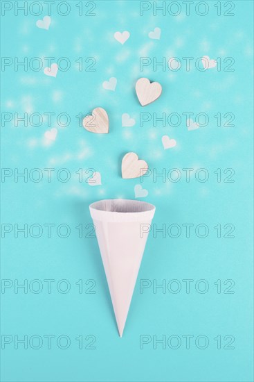 Cone with rose colored hearts, blue background, birthday and valentines day greeting card,