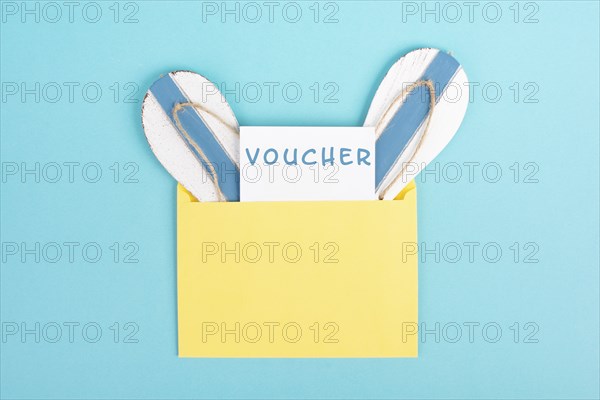 Blue colored summer and vacation background, voucher, flip flops in an envelope, copy space for