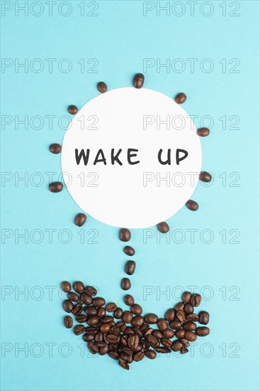 Flower made with coffee beans, the words wake up are standing on the blossom, good morning, having