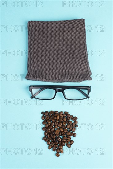 Human face made with a wool hat, glasses and coffee beans as a beard, funny minimalist portrait,