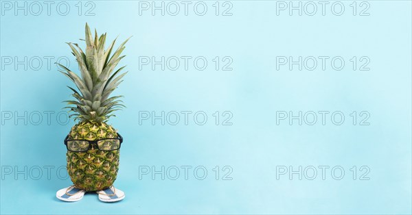 Pineapple with glasses and flip flops, vacation and travel concept, tropical summer holiday, funny