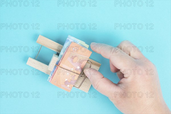 Euro banknotes in a mousetrap, bank loan, finanicial debt, inflation, risky credit and investment,