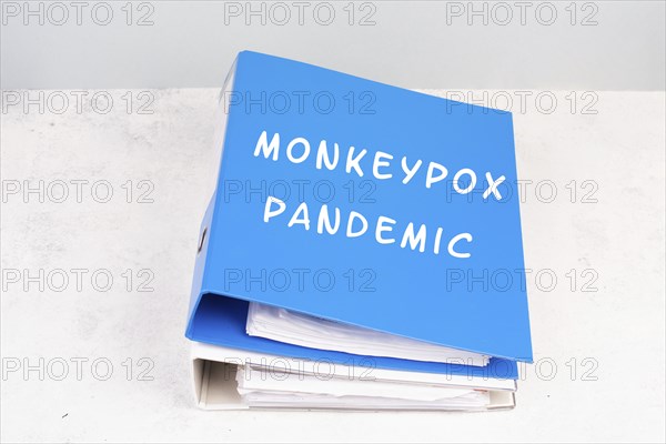 The words monkeypox pandemic are standing in german language on a folder, outbreak of the MPXV