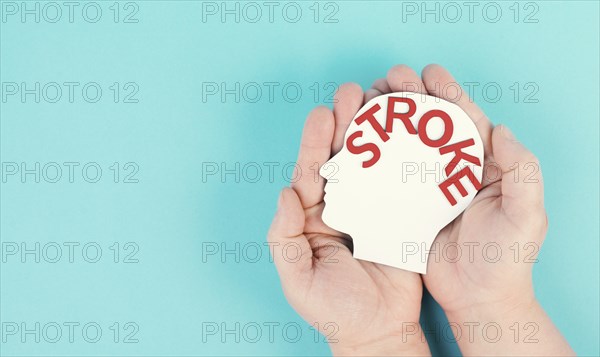 Holding a head with the word stroke in the hand, brain injury, ischemic and hemorrhagic types,