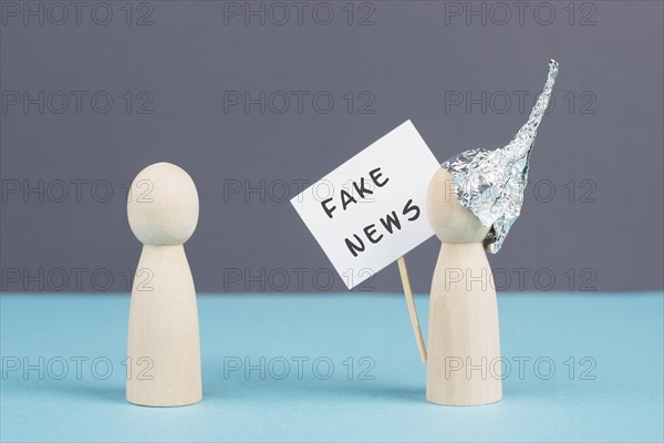 Alu hats protester talking to a person, conspiracy theories, tin foil on the head, holding a sign