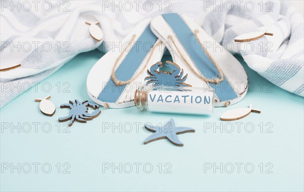 Blue colored summer and holiday background, flippers, sea stars and a glass bootle with the word