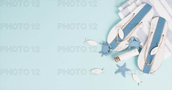 Blue colored summer and vacation background, slippers and sea stars building a frame, copy space