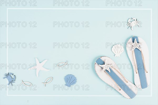 Blue colored summer and holiday background, flip flops, sea stars and fish with copy space, travel