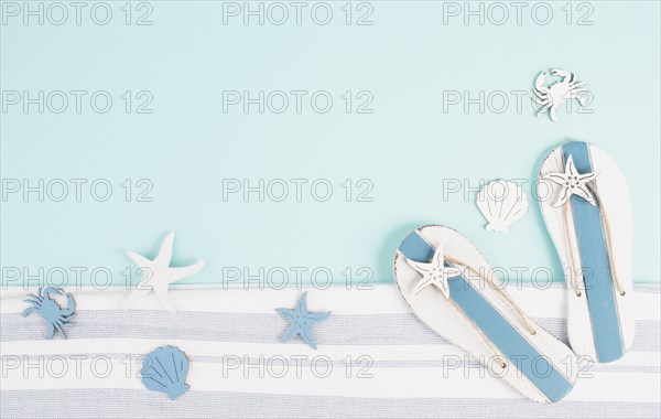 Blue colored summer and holiday background, flip flops, sea stars and fish with copy space, travel