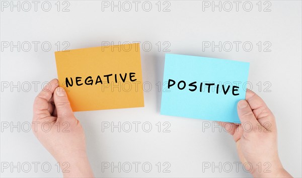 The words negative and positive are standing on paper, business and service rating, evaluation