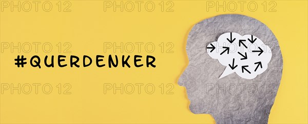 Think different stands in german language on the yellow background, head with brain, being a