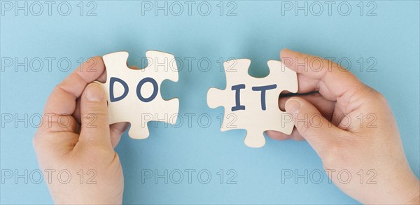 The words do it are standing on two puzzle pieces, positive mindset, motivation and coaching