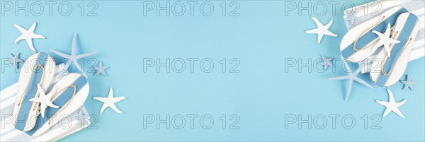 Blue colored summer and vacation background, slippers and sea stars building a frame, copy space