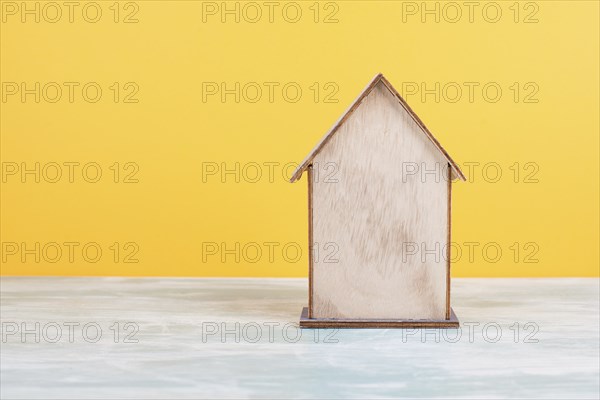 Wooden house, yellow background, buying or renting a house, real estate concept, booking home for
