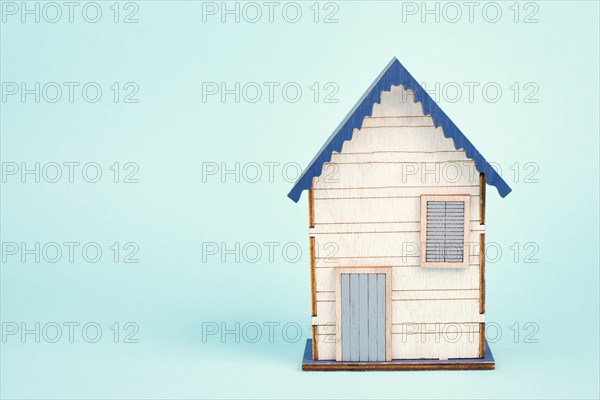 Wooden house, blue background, buying or renting a house, real estate concept, booking home for