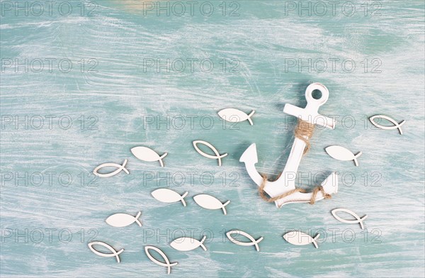 White anchor and fish on a blue background, maritime sea life, sailing trip, summer vacation,