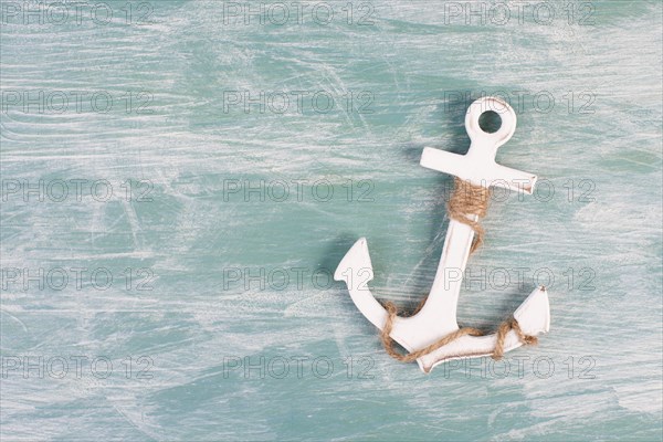 White anchor on a blue textured background, maritime sea life, sailing trip, summer vacation,