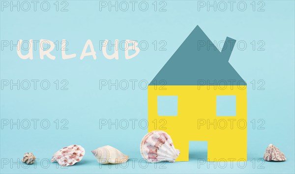 Colorful house on a blue colored background with sea shells, booking an appartment, hotel or lounge