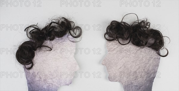 Silhouette of two faces with hair looking to each other, communication, having an opinion and