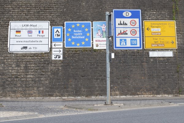 Border crossing to Germany, many road signs inform about speed limits and toll fees on german