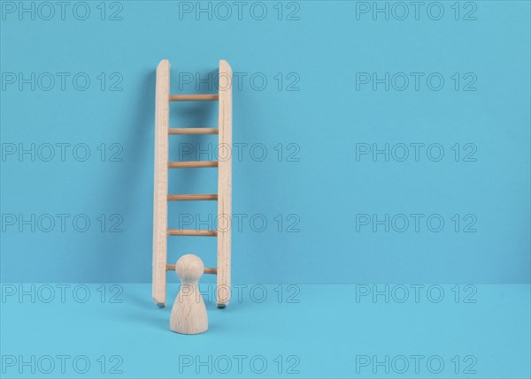 Man is standing next to a ladder, climbing up in career, having a goal, brainstorming for ideas,