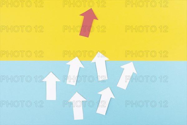 White arrows on a green background, one red is standing out, do different, be a winner,