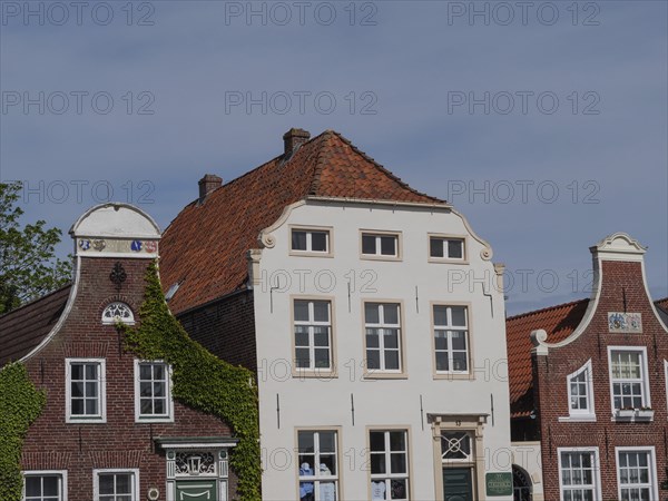 Picture of several historic building facades with decorated gables in an old town under a blue sky,