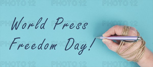 World Press Freedom Day is standing on a paper, hand with pen is chained, free speech, cancel
