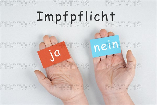 Mandatory vaccination, german language, yes and no is standing on paper, making a decision,