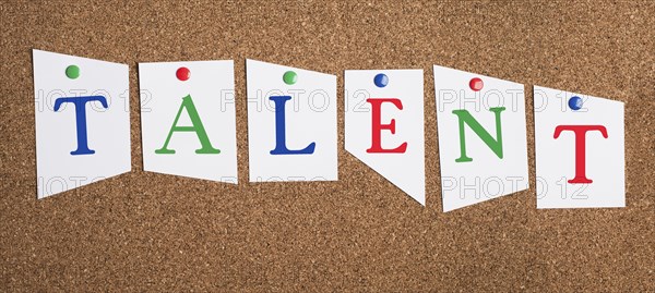 The word talent is standing in colorful letters on a corkboard, unique skill, having a passion,