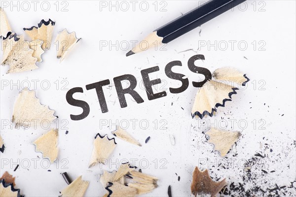 The word stress is standing on a paper, pen with eraser, burnout concept