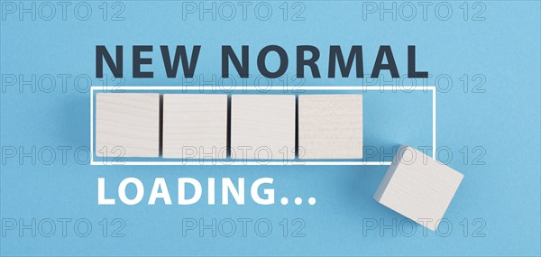 The words new normal are standing on wooden cubes, loading bar, blue colored background