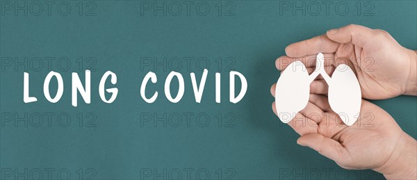 The words long covid are standing on a paper, hands hold a lung, breathing problems after Covid-19