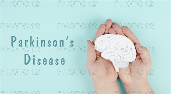Parkinson's disease is standing on a paper, hands holding brain, dementia diagnosis, Alzheimer's