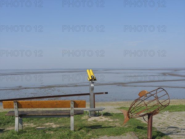 Viewing platform with bench, yellow telescope and a fish sculpture with a view of the sea, Ditzum,