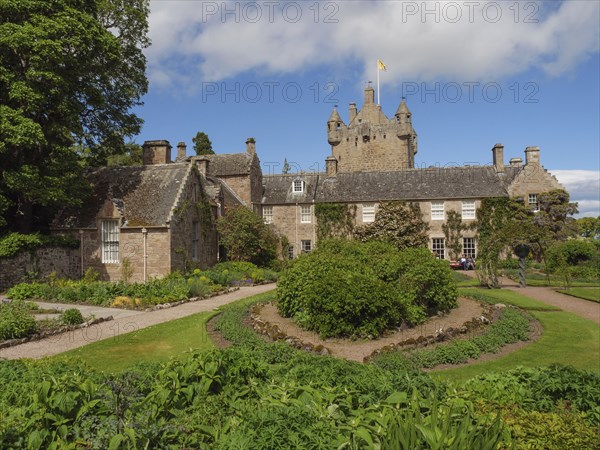 Historic castle with towers and surrounding garden, lush vegetation and a sunny sky, inverness,