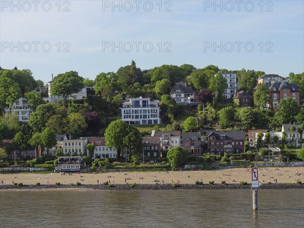 Beach view with buildings behind and a lot of green landscape on the shore, Elbe, Hamburg, Northern