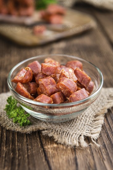 German Mettwurst (Chilli flavoured) as close-up shot (selective focus) on wooden background