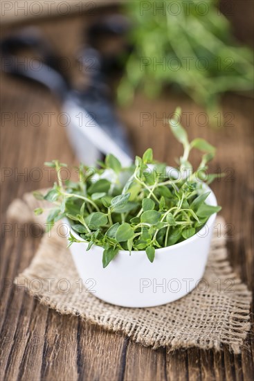 Fresh Thyme (close-up shot, selective focus) on wooden background