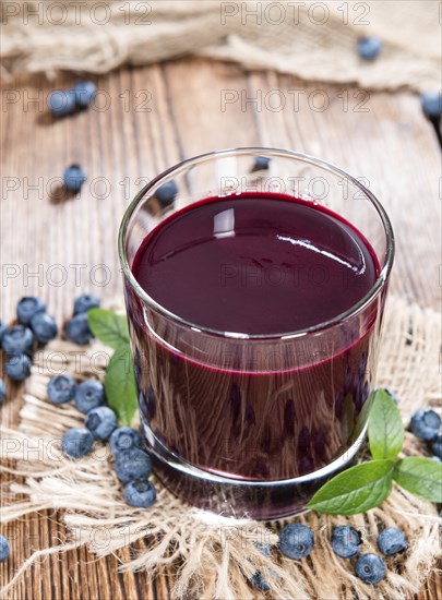 Fresh made Blueberry Juice with some fruits on wooden background