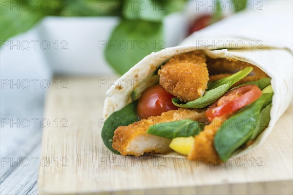 Chicken Wraps on a wooden table as detailed close-up shot (selective focus)