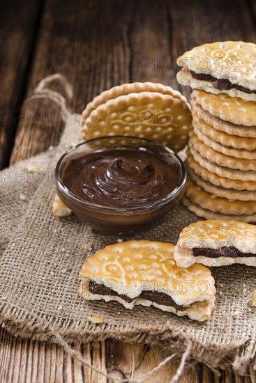 Portion of Chocolate Cream Cookies (on wooden background)