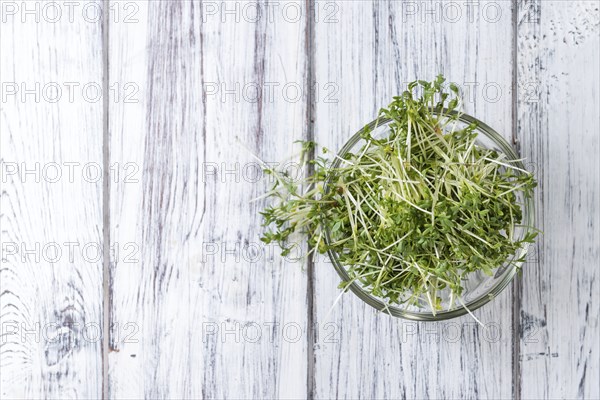 Portion of Cress (close-up shot) on rustic wooden background
