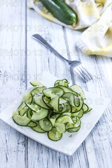 Homemade Cucumber Salad with onions and dill on a wooden table