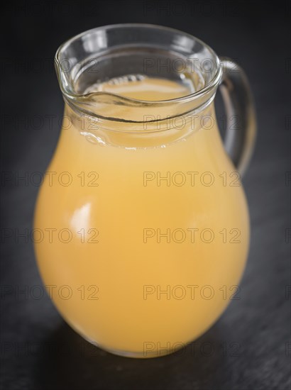 Portion of Juice (apple) on a rustic slate slab (selective focus, close-up shot)